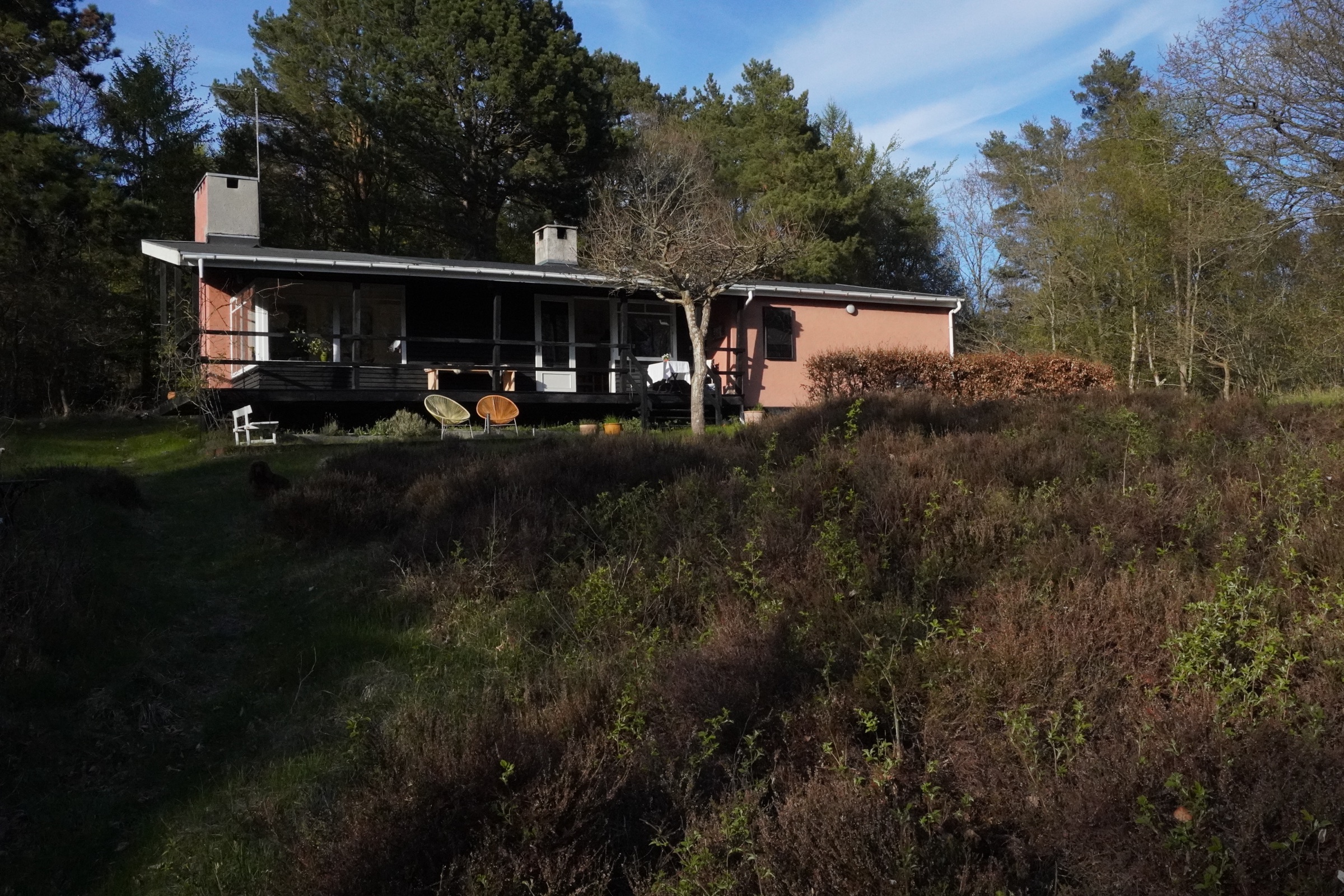 Sommerhuset set fra haven med terrasse og beplantning