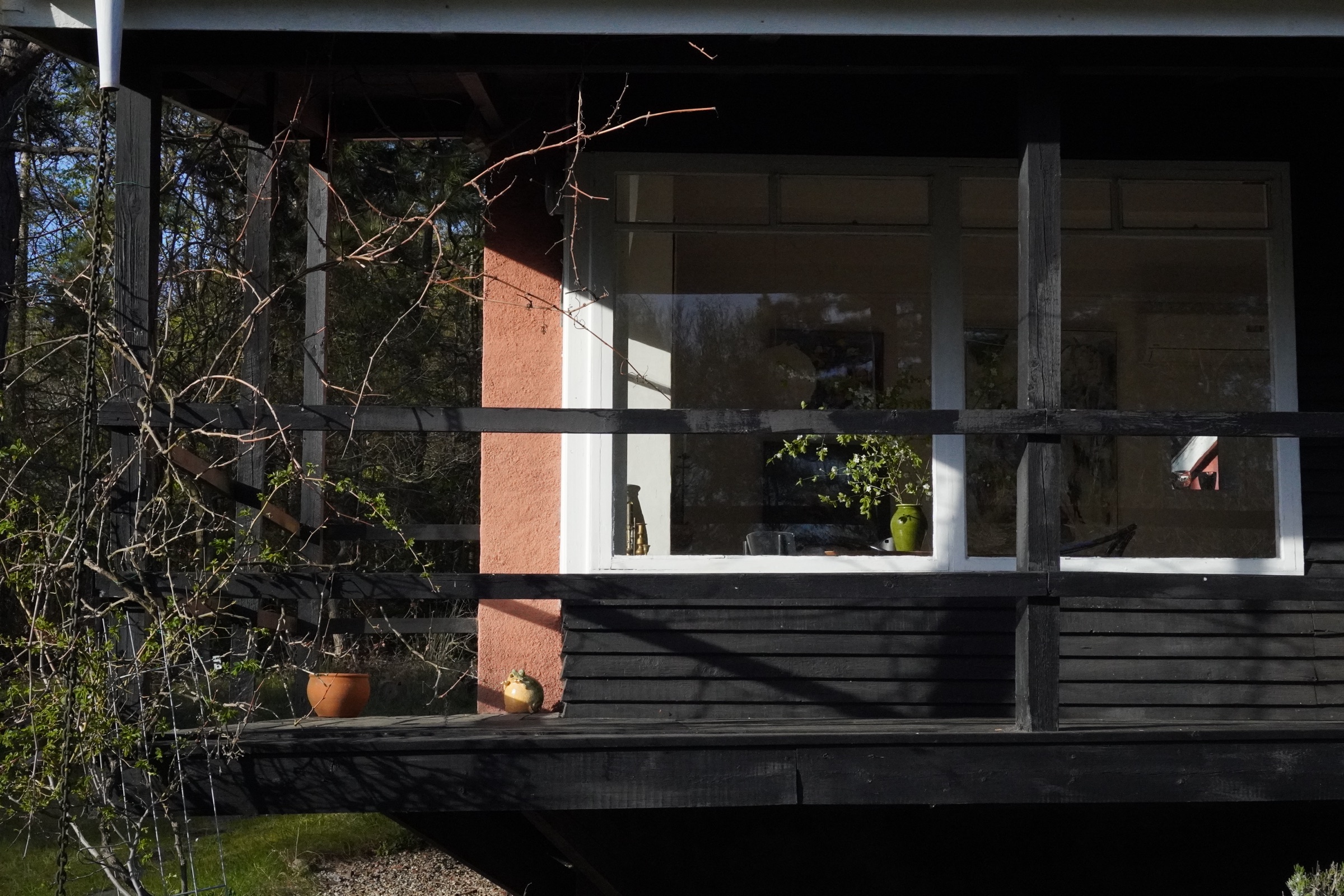 Sommerhusets facade og tag mod den lyngklædte naturgrund