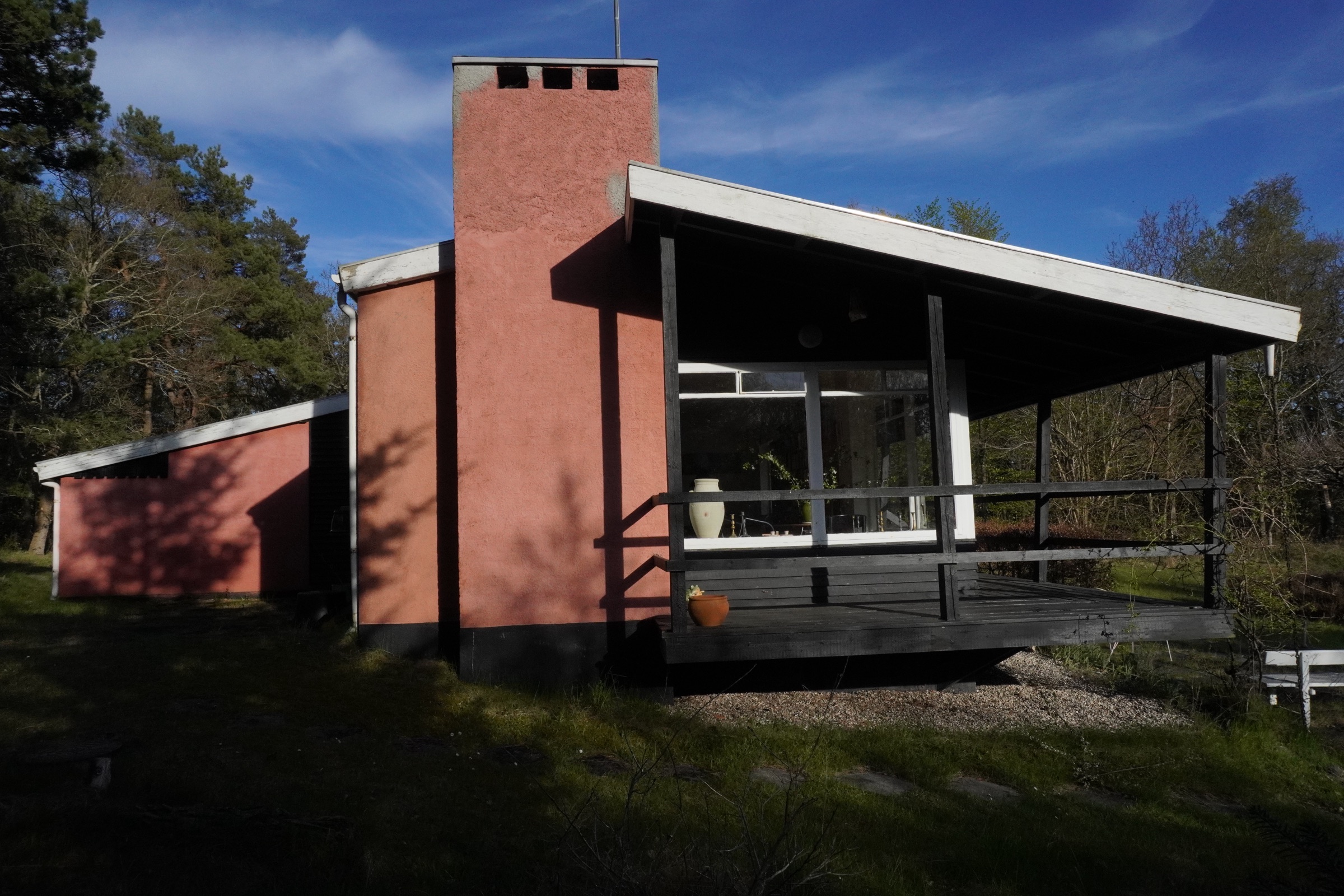 Terrasseområde langs sommerhuset med udsigt til skovgrunden